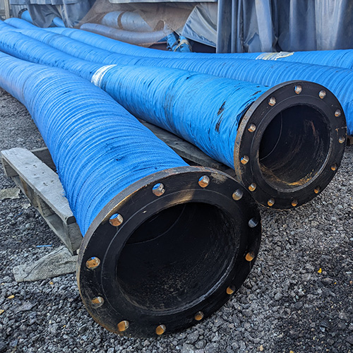 heavy duty slurry and discharge hose sitting in a storage yard