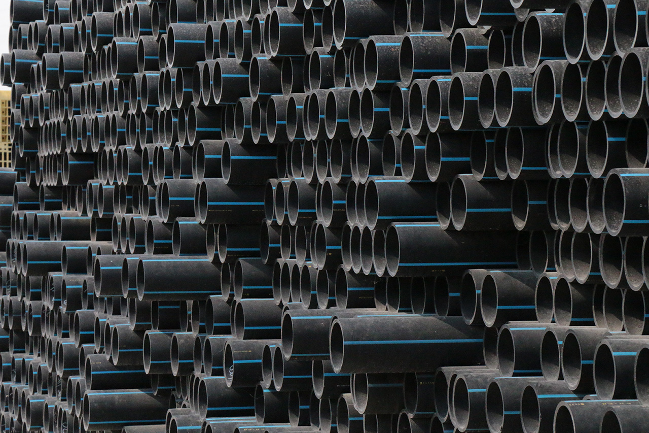 a large, well piled stack of lower diameter HDPE pipe