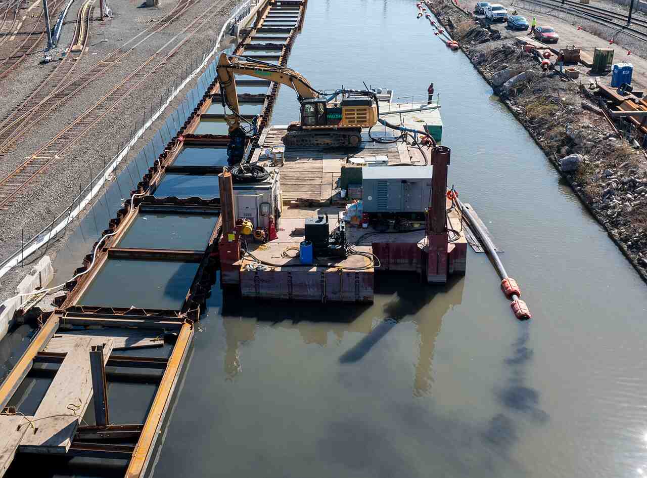 Excavator dredging silt from a canal
