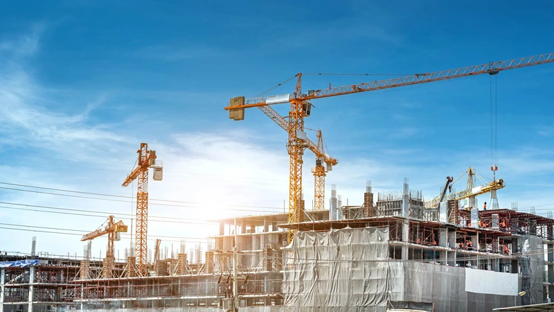Active construction site showing multiple tower cranes and