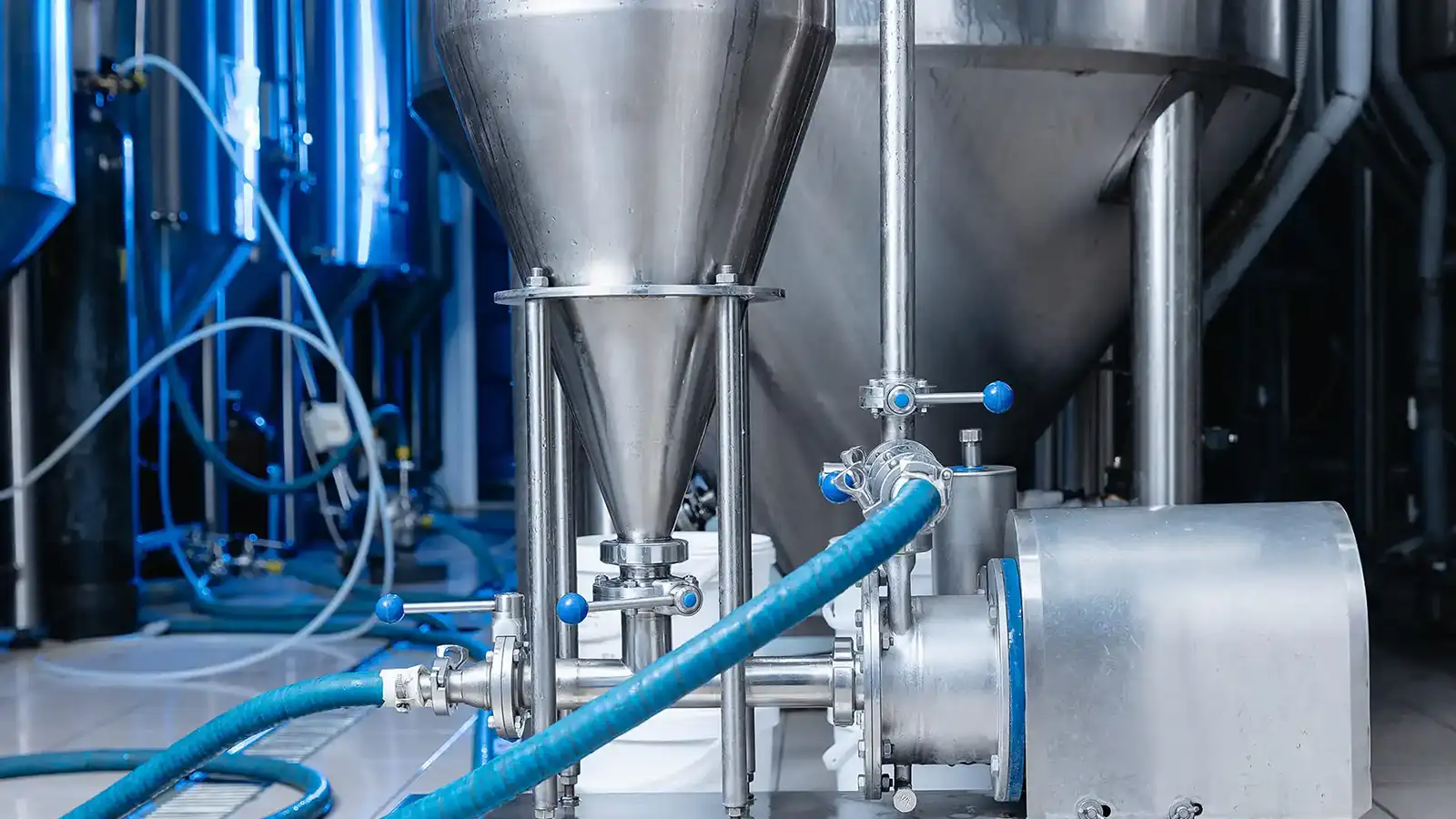 Industrial manufacturing facility using pipe and hose systems for cooling water circulation, process flow, and material handling in continuous production operations