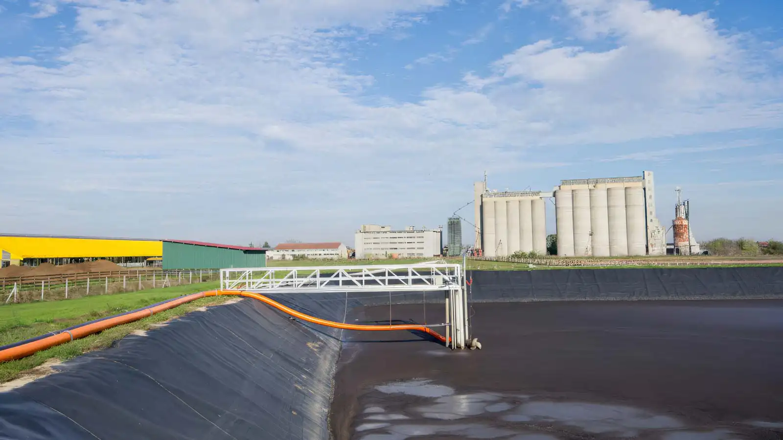 Agricultural drag hose system pumping liquid manure from centralized storage lagoons through 5-inch hose lines up to 5,000 feet to field injection toolbars, eliminating tanker traffic across a 3,200-acre operation